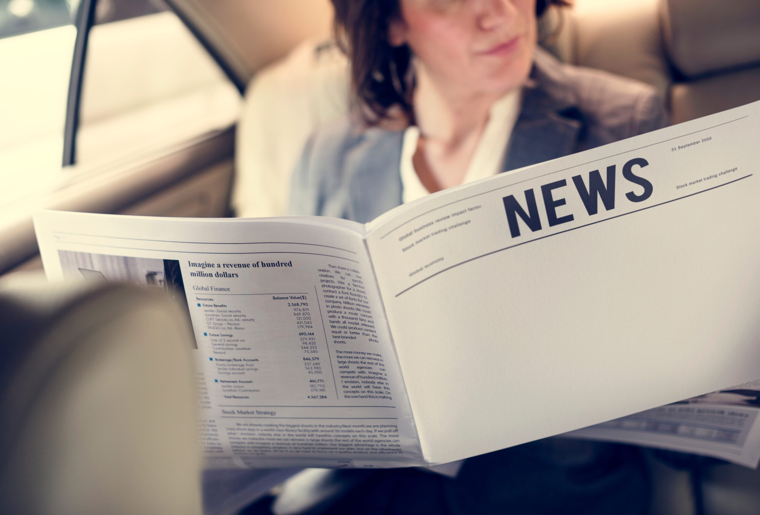 Femme d'affaires lisant un journal dans une voiture