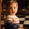 Bébéd'environ 18 mois avec un pull jacquard
