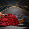 Portrait de mode d'une belle femme en robe longue assise sur un canapé